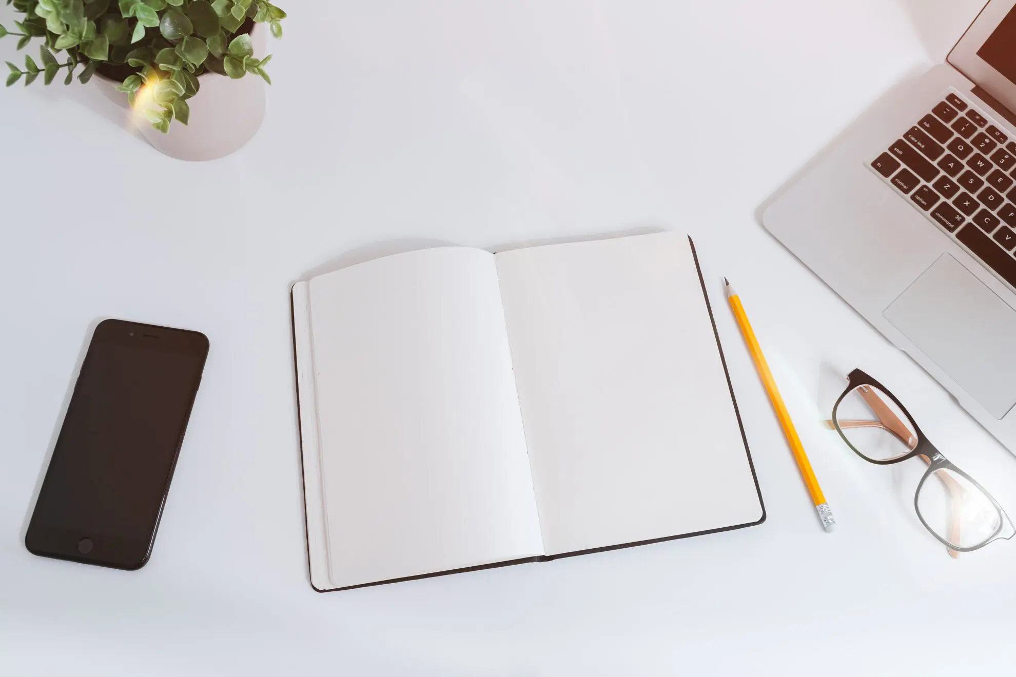 Bureau organisé avec ordinateur, cahier et smartphone