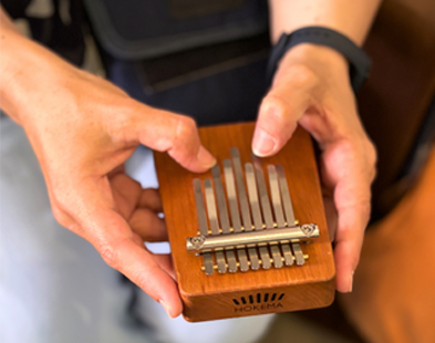 montantlibre Mains tenant une petite kalimba en bois