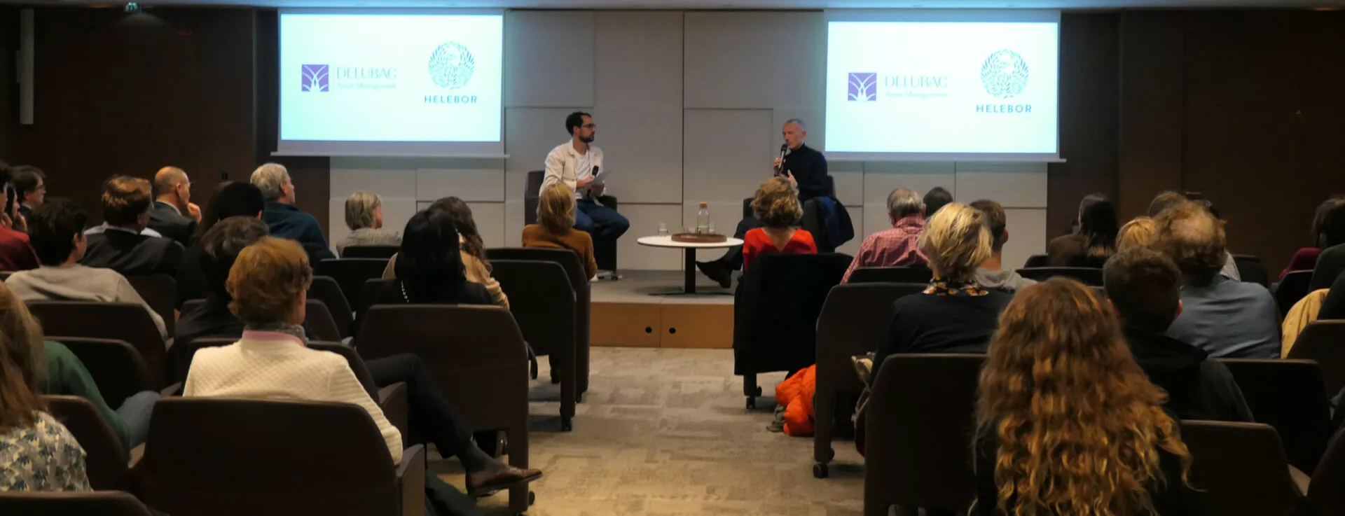 Conférence dans une salle avec écrans et public